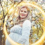 Portret kobiety w ciąży o zachodzie słońca z efektem "fire ring"